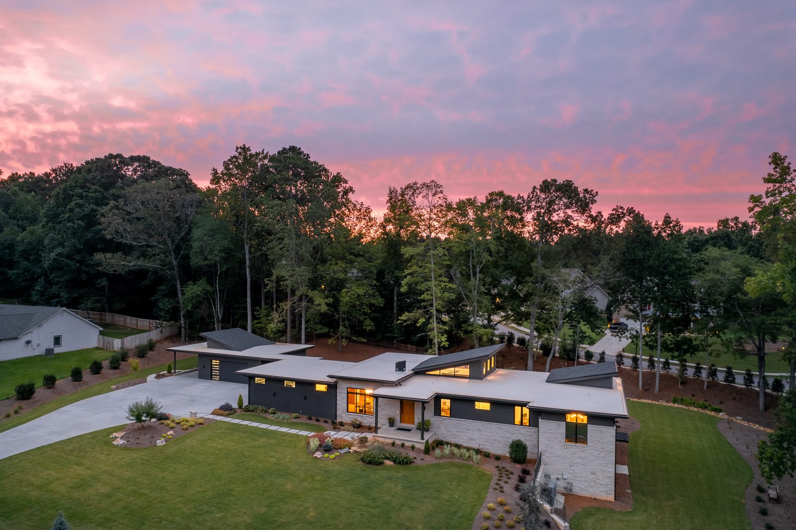 Twilight view of the house, drive court and garage — The Ortiz Home, custom home built by Ironwood Construction Group in Sugar Hill, Georgia