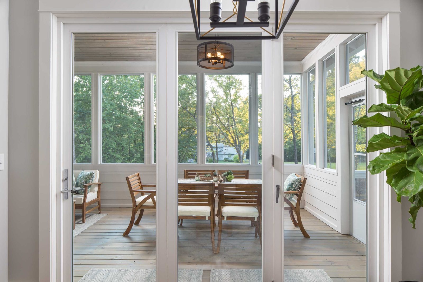 Folding glass doors opening onto the screened porch — Austin Garner Rd, custom home built by Ironwood Construction Group