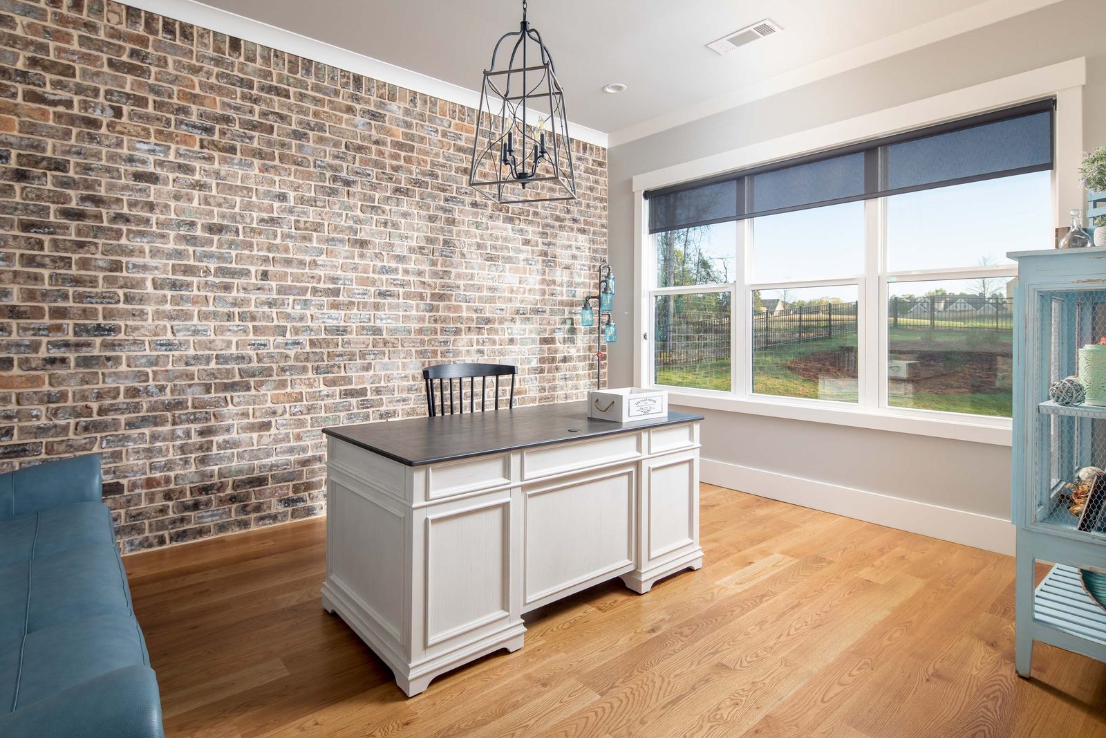 Kitchen island standing against the exposed brick wall — Glausier, custom home built by Ironwood Construction Group
