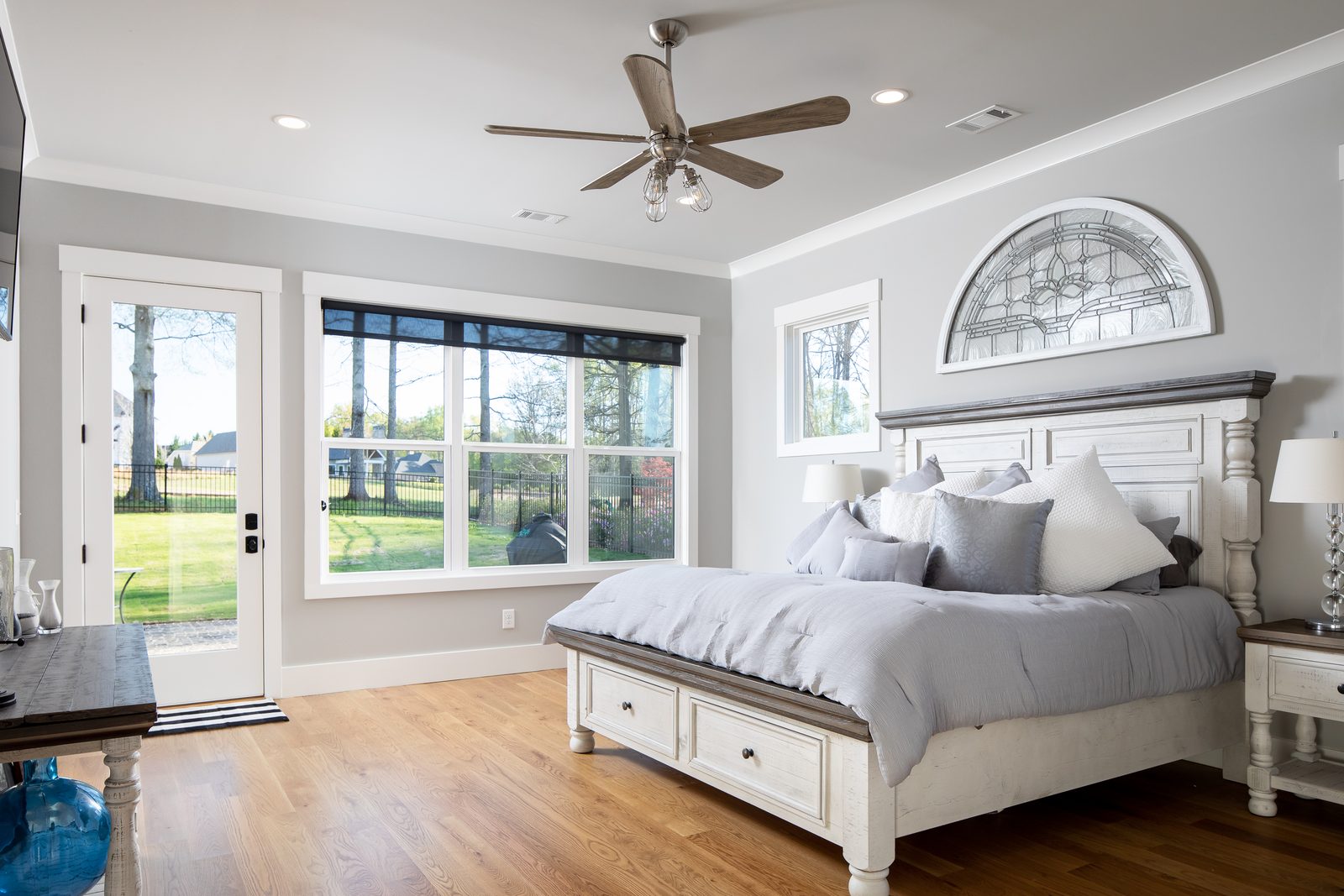Primary bedroom with arched transom window and ceiling fan — Spring 2020 Custom Home, custom home built by Ironwood Construction Group