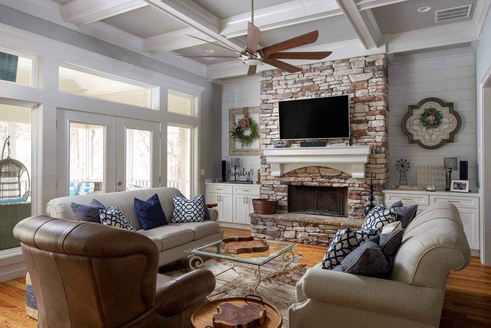 Great room with stacked-stone fireplace and coffered ceiling — Spring 2020 Custom Home, custom home built by Ironwood Construction Group
