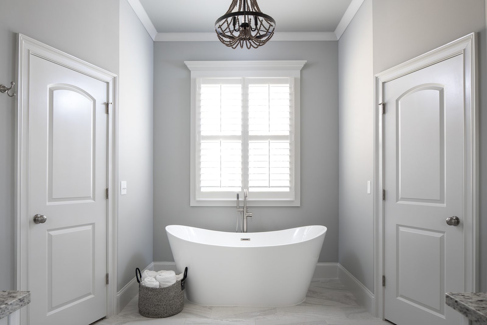 Primary bath with freestanding tub between the closet doors — Spring 2020 Custom Home, custom home built by Ironwood Construction Group